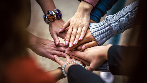 Several hands coming together to show teamwork